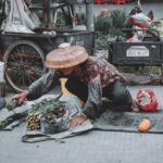 Vendedora organiza verduras en un mercado