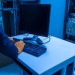 Técnico trabaja en un computador dentro de un centro de datos