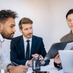 Tres profesionales revisan documentos frente a un computador