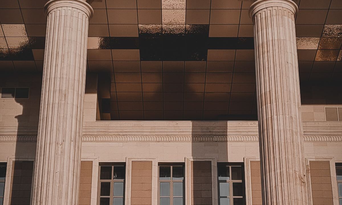 Sentencia C-196 del 24-06-2026. Renta. Exequibilidad de la sobretasa para los sectores asegurador, bursátil y del mercado de valores. 13 Columnas en la entrada de un edificio judicial