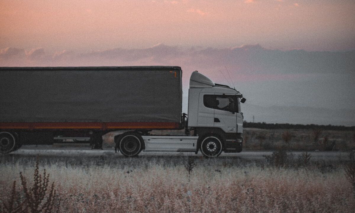 Concepto 014737 (int. 1412) del 19-08-2026. IVA. Transporte de bienes bajo demanda prestado por personas naturales. 14 Camión de carga en una carretera al atardecer