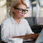 Mujer trabaja en su computador portátil en una oficina