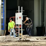 Trabajadores instalan un tablero eléctrico en una obra