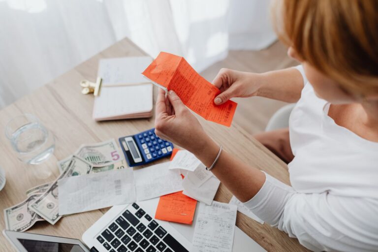 Persona organiza facturas y recibos con una calculadora