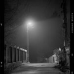 Lámpara de alumbrado público sobre una calle rural de noche