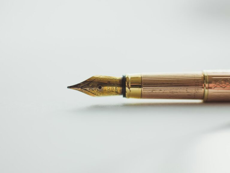Concepto 015661 del 07-09-2026. Procedimiento. Firma del revisor fiscal en declaraciones y correcciones. 4 Pluma estilográfica dorada sobre superficie blanca