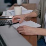 Persona revisando documentos y cifras en un escritorio de oficina