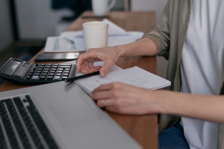 Persona revisando documentos y cifras en un escritorio de oficina