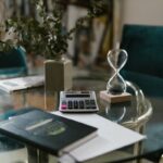Calculadora, libreta y reloj de arena sobre una mesa de vidrio