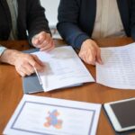 Dos profesionales revisan documentos durante una reunión de negocios