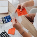 Persona revisando recibos y facturas con una calculadora
