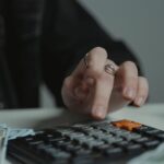 Persona usando una calculadora sobre una mesa