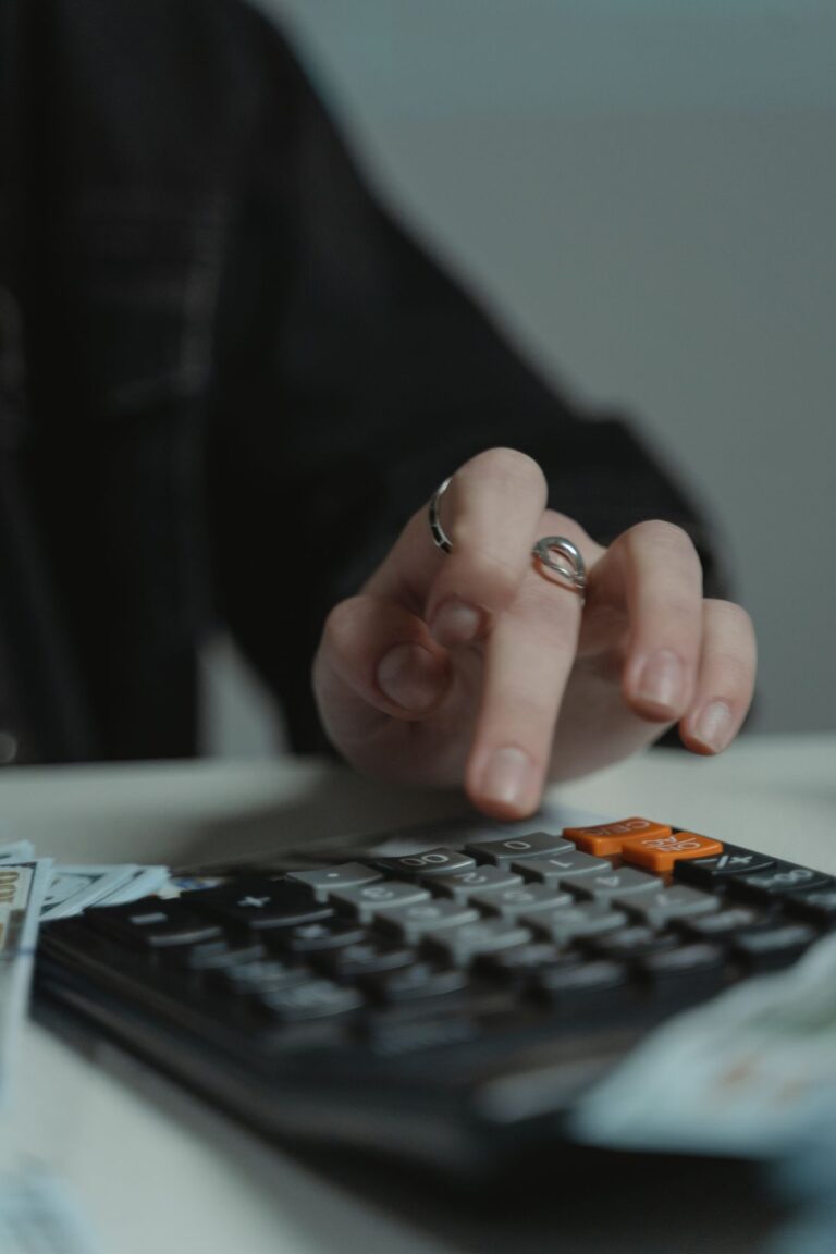 Persona usando una calculadora sobre una mesa