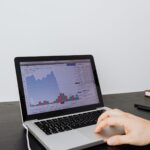 Persona analizando gráficas financieras en un portátil