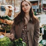 Mujer compra verduras frescas en un mercado al aire libre
