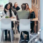 Grupo de trabajadores reunidos alrededor de una mesa de trabajo