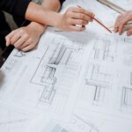 Profesionales reunidos alrededor de una mesa revisando planos de construcción