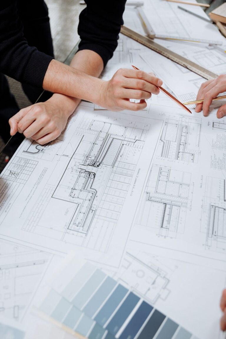 Profesionales reunidos alrededor de una mesa revisando planos de construcción