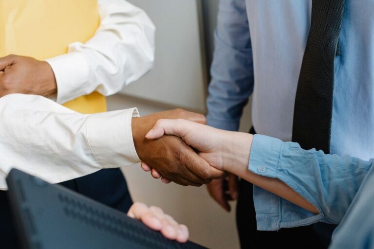 Colegas de distintos orígenes se dan la mano en una reunión de trabajo