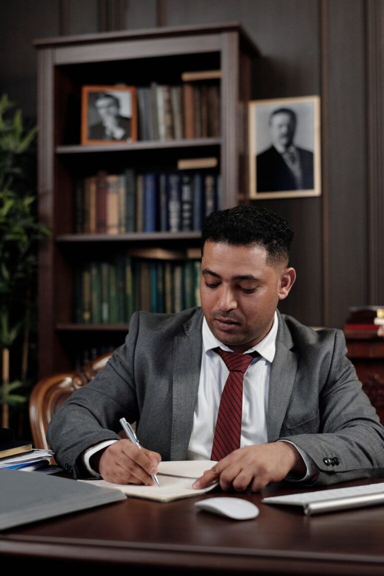 Profesional en traje firma un documento en su escritorio de oficina