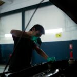 Sentencia 30759 del 25-09-2026. IVA. Venta de aceite con instalación gratuita y prueba de los ingresos que se pretenden excluir. Mecánico revisa el nivel de aceite del motor de un vehículo en un taller