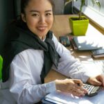 Profesional trabajando con calculadora y portátil en una oficina