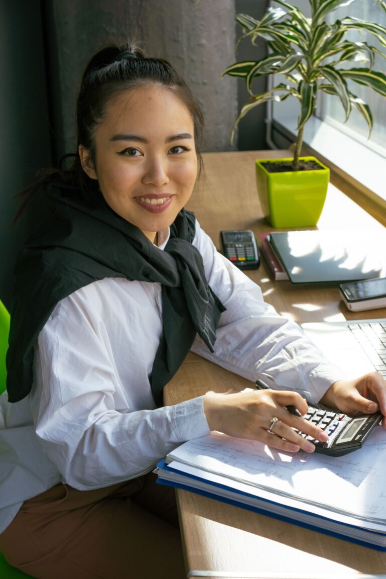 Profesional trabajando con calculadora y portátil en una oficina