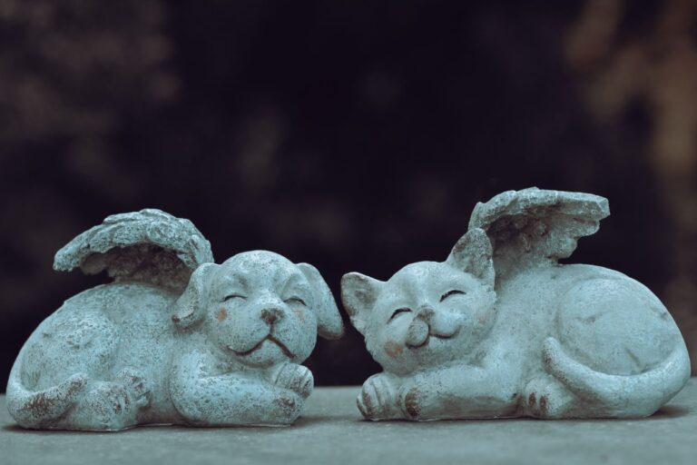 Figuras de piedra de un perro y un gato con alas de ángel