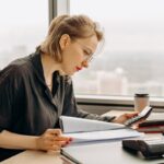 Contadora calcula valores con una calculadora en su escritorio