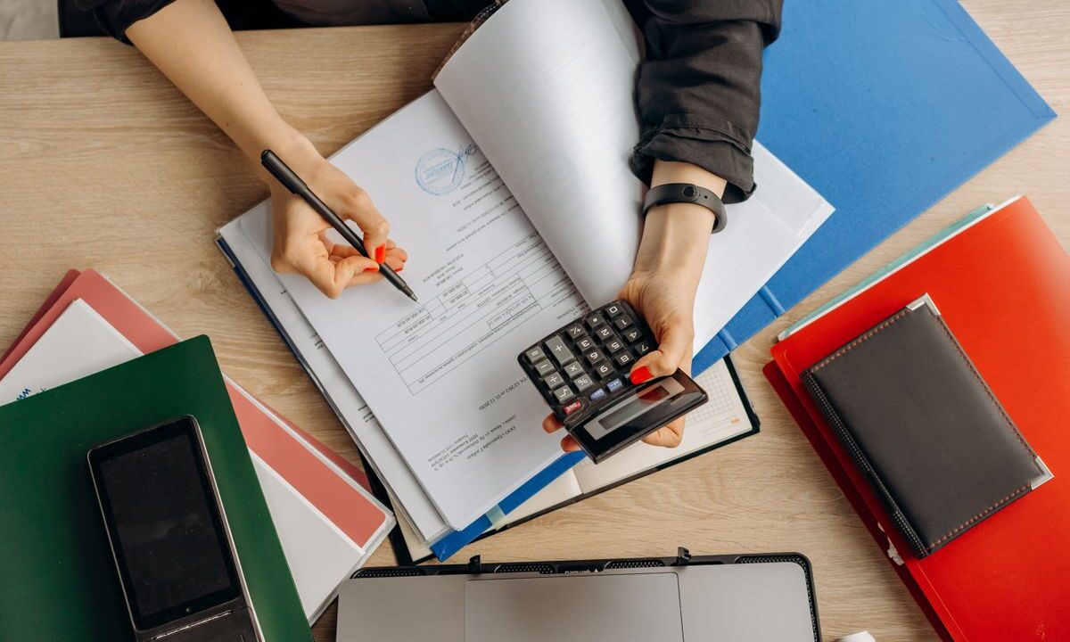 Contadora analizando documentos financieros con una calculadora