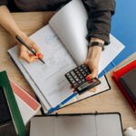 Contadora analizando documentos financieros con una calculadora