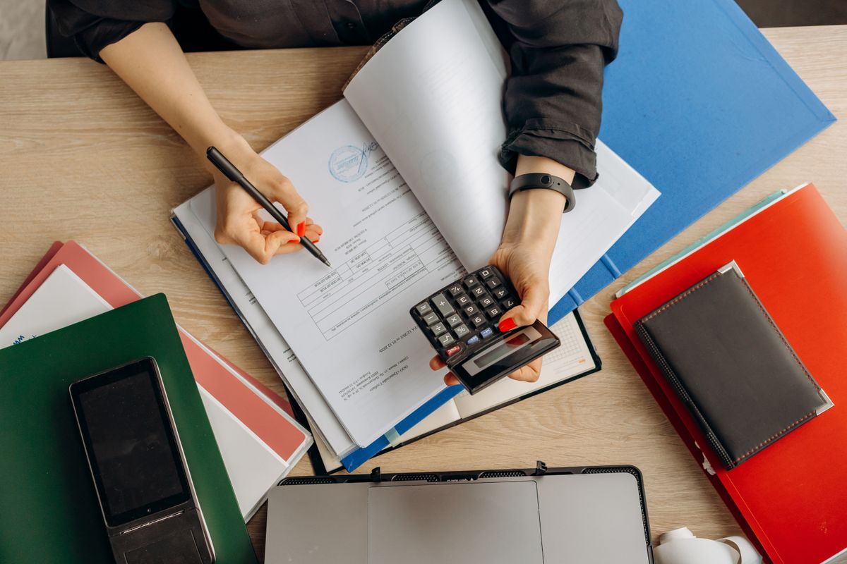 Contadora analizando documentos financieros con una calculadora