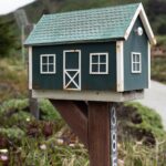 Concepto DAF 055964 del 04-08-2026. Territorial. Procedimiento. Notificación de las liquidaciones oficiales y de la factura del impuesto predial. Buzón de correo de madera en el jardín de una vivienda