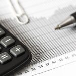 Calculadora y bolígrafo sobre un gráfico de barras