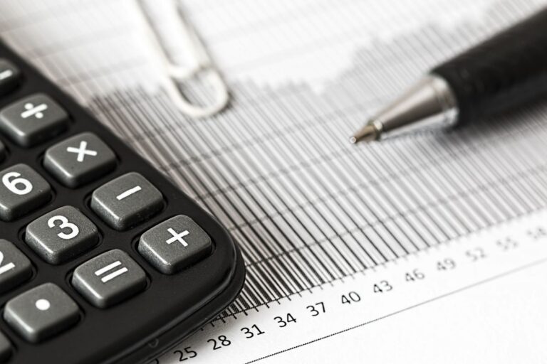 Calculadora y bolígrafo sobre un gráfico de barras