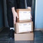 Persona organizando cajas de cartón con mercancía lista para entregar