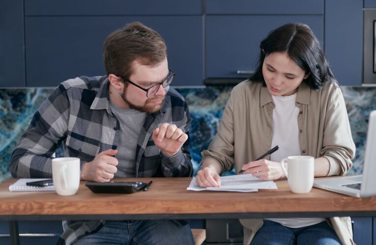 Concepto 016547 del 21-09-2026. Renta. Impuesto que se resta en la determinación de la renta por comparación patrimonial. 18 Pareja revisa documentos financieros en una mesa de madera