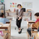 Docente de pie frente a sus estudiantes en un salón de clase