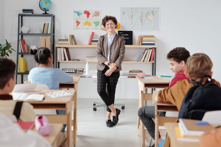 Docente de pie frente a sus estudiantes en un salón de clase
