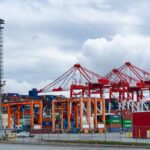 Grúas portuarias y patio de contenedores en una terminal de carga