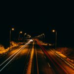 Vía iluminada por postes de alumbrado público en la noche