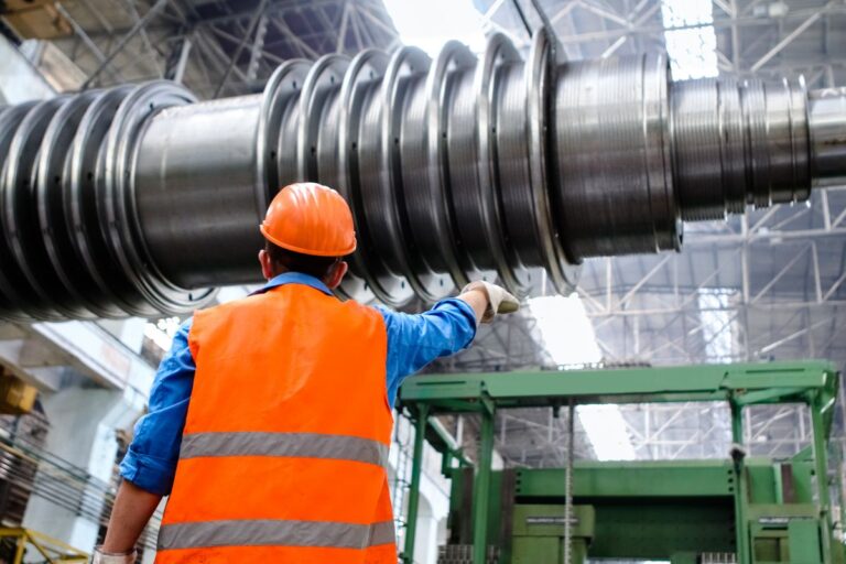 Trabajador con casco y chaleco de seguridad en una planta industrial del sector energético