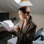 Contadora con gafas revisa documentos financieros en su escritorio