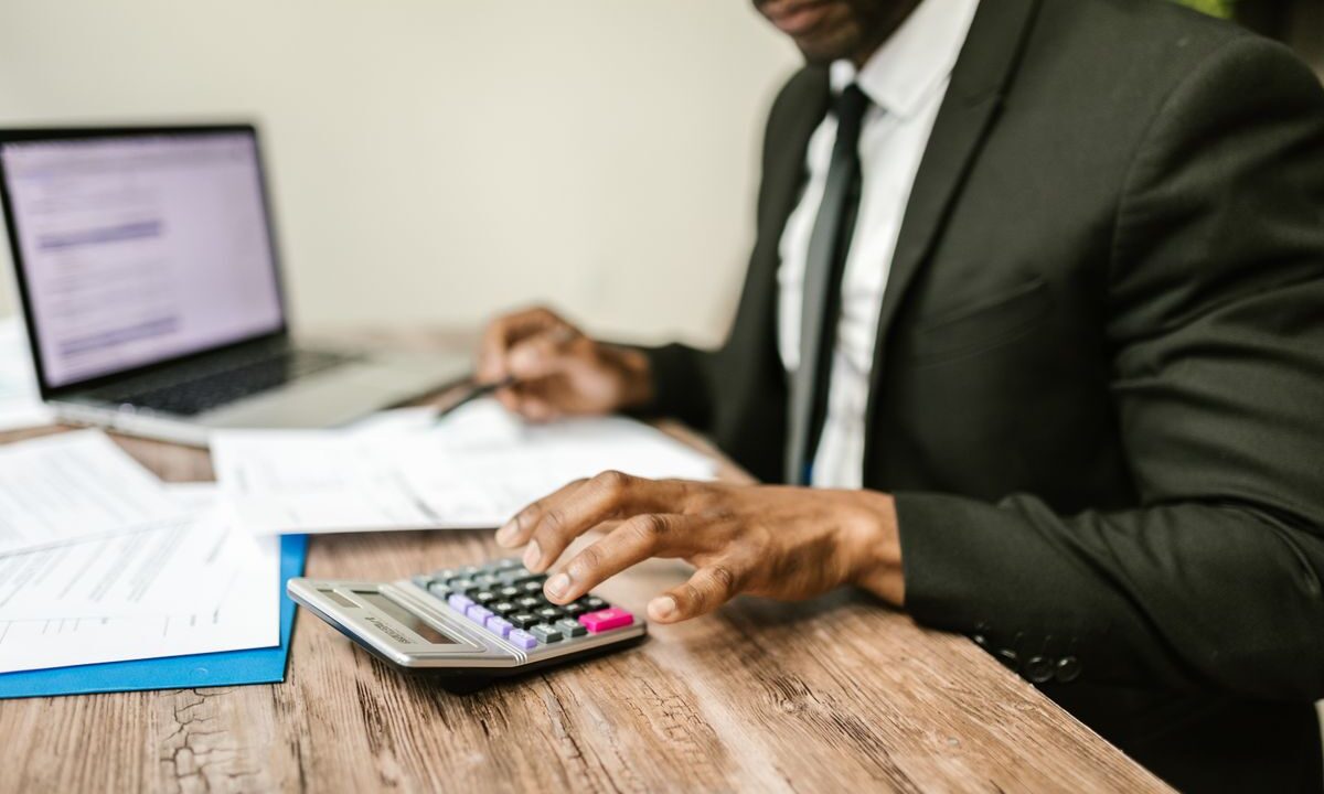 Profesional revisando documentos financieros con una calculadora