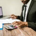Profesional revisando documentos financieros con una calculadora