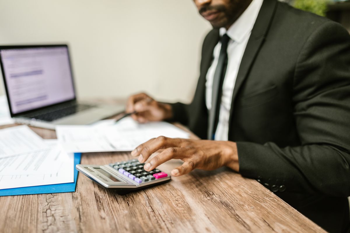 Profesional revisando documentos financieros con una calculadora