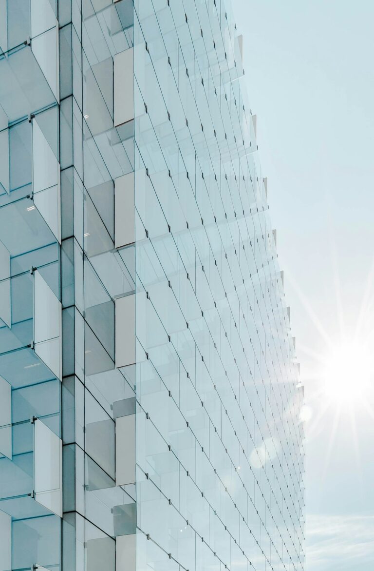 Edificio de vidrio de gran altura bajo cielo azul