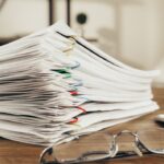 Pila de documentos con ganchos sobre un escritorio