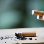 Cigarrillo con ceniza sobre una superficie