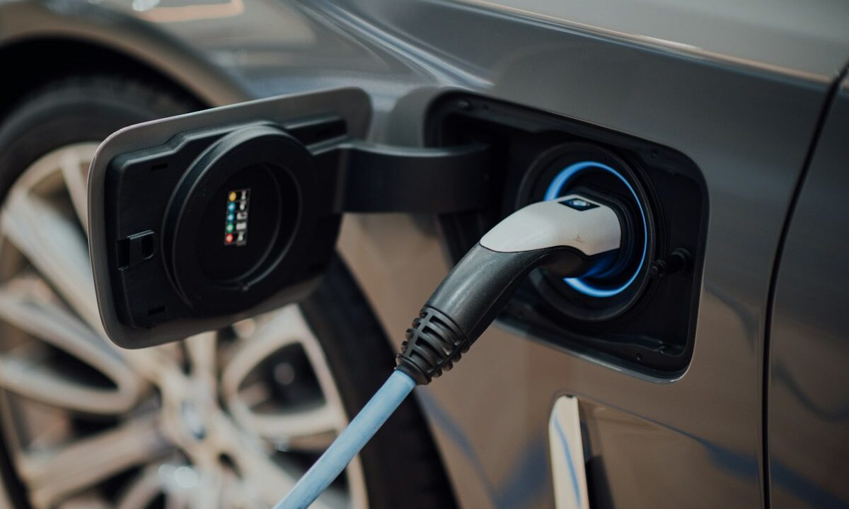 Comunicado de prensa DIAN 127 del 01-10-2026. IVA. Devoluciones por compra de vehículos híbridos y eléctricos. 11 Cable de carga conectado a un vehículo eléctrico